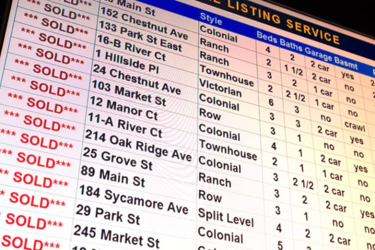 A spreadsheet on a screen shows homes recently sold.